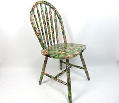 a wooden chair with floral designs on it's back legs and seat, against a white background