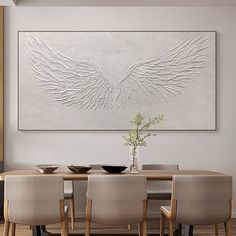 a dining room table with chairs and a large painting on the wall