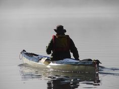 a man is paddling his kayak in the water