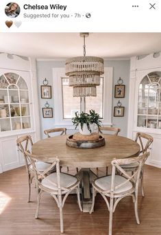 a dining room table with four chairs and a chandelier hanging from the ceiling