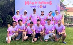 a group of people in pink shirts posing for a photo