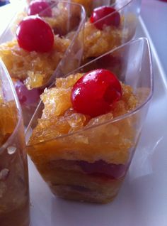 small desserts with cherries and pineapple toppings sit on a white plate