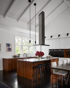 a kitchen with an island, stove and dining room table in it's center