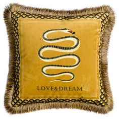 a yellow pillow with a snake on it and the words love & dream written in black