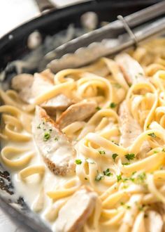 a skillet filled with pasta and meat