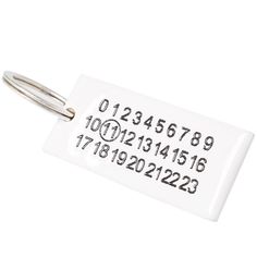 a close up of a key chain on a white surface with numbers and letters printed on it