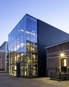 a large glass building with stairs leading up to it's top floor and windows