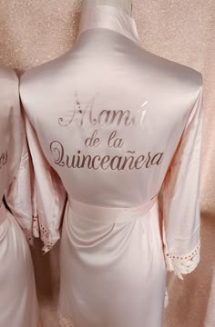 two bridesmaids in pink robes with embroidered names on them