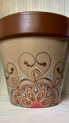 a flower pot with designs painted on it