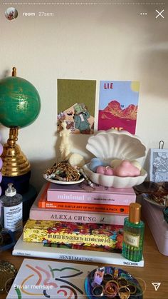 a stack of books sitting on top of a table next to a lamp and other items