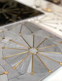 an intricately designed marble table top with gold circles and dots on the edges is seen in this image