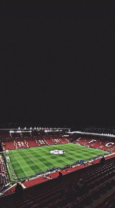 an empty soccer stadium at night with the lights on and fans in the stands watching