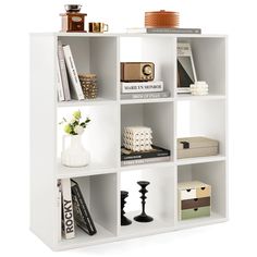 a white book shelf with books and other items on it's shelves, against a white background