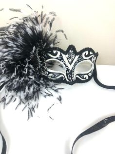 "Feather mask- NYC -Masked ball- New Years Eve- White and black Masquerade Ball- Mardi Gras -Halloween Hello, Made and ready to ship in 1-2 business days. Perfect for a masquerade party, birthday celebration, costume party, New Years Eve celebration or Mardi Gras. These feathers are on the side of a plaster mask that's black and white with some glitter. A beautiful brooch sets it all off! Made with a black sparkle tie. The feathers are about 6\" long. It's on a very comfortable mask...ages 16 an Gothic Mardi Gras Costume Mask, Gothic Masks And Prosthetics For Mardi Gras Carnival, Gothic Masks And Prosthetics For Carnival And Mardi Gras, Halloween Carnival Eye Masquerade Mask, Venetian Costume Accessories For Carnival, Black Fantasy Eye Mask, Fantasy Style Black Eye Mask, Fantasy Black Eye Mask, Black Masquerade Mask Costume Accessories