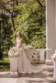 a woman in a wedding dress sitting on a bench