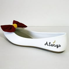 a white shoe with a red bow and name on it