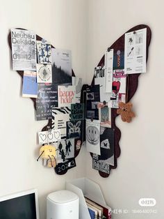 a butterfly shaped mirror sitting on top of a wall next to a computer monitor and keyboard