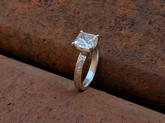 a diamond ring sitting on top of a stone wall in front of a brick wall