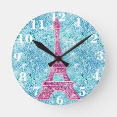 a clock with the eiffel tower in pink and blue glitters on it