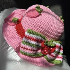 a crocheted pink hat with green and white stripes on the brimmed