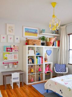 a child's bedroom with toys and decor on the walls, including bookshelves