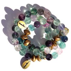 An assortment of  semi transparent beads. Purple, blue, clear & green beads with a  few brass accent beads and a brass Often Wander charm. Spiritual Fluorite Bracelet For Healing, Spiritual Fluorite Bracelets For Gifts, Messy Thoughts, Handmade Spiritual Fluorite Bracelet, Spiritual Fluorite Gemstone Beads Jewelry, Friendship Encouragement, Multicolor Gemstone Fluorite Jewelry, Soul Purpose, Puzzle Crafts