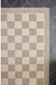 a beige and white rug on top of a tile floor