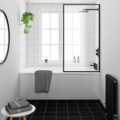 a bathroom with black and white tile flooring and walls, along with a bathtub