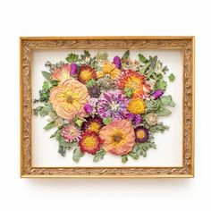 an image of a bouquet of flowers in a gold frame on a white wall or floor