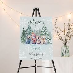 a welcome sign with three puppies in front of snow covered trees and christmas lights