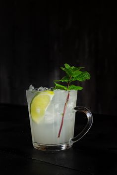 a glass filled with ice and lemon on top of a table