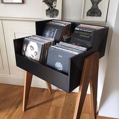 a wooden stand with several records in it