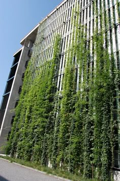 a tall building with lots of green plants growing on it's side