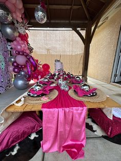 the table is set up with pink and silver decorations for a masquerade party