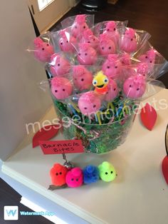 a vase filled with lots of pink candies on top of a table