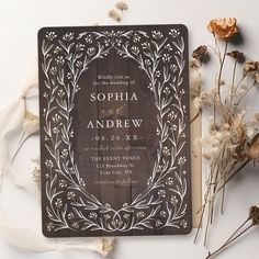 a wooden wedding card on top of some dried flowers