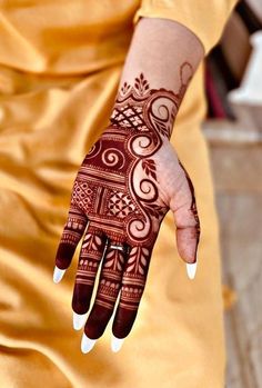 a woman's hand with henna tattoos on it