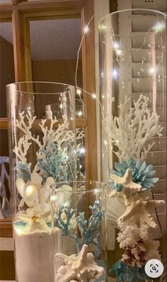 two glass vases filled with white and blue decorations