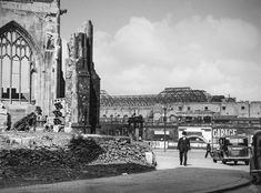 an old black and white photo of a man walking down the street in front of a building