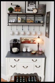 a coffee bar with two shelves above it and cups hanging on the wall next to it