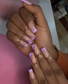 a woman's hands with pink nail polish and long, pointed nails on them