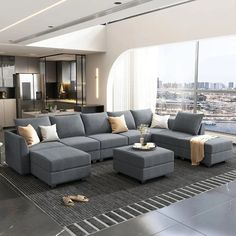 a living room filled with furniture and a large window overlooking a cityscape in the distance