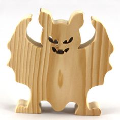 a wooden toy that is shaped like a bat with its wings spread out and eyes wide open