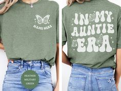 Announce your special news in style with our 'In My Auntie Era' shirt! This personalized tee is the perfect gift for the cool aunt in your life. Embrace retro vibes with this unique design, making it a standout piece in any wardrobe. Whether it's a baby announcement or simply celebrating your aunt's awesomeness, this shirt is sure to make a statement. Shop now and surprise your favorite aunt with a gift she'll cherish forever! ✨PRODUCT DETAILS This listing contains T-shirts in Gildan unisex sizes. Please refer to the product listing photos, as there is a size and color chart for these shirts, as well as a description of its product details.  ✨HOW TO ORDER 1️⃣ Please check and review all photos. 2️⃣ Select your size and color from the drop-down menus. 3️⃣ Choose the quantity you want. 4️⃣ C Aunt Squad Shirt, In My Auntie Era Shirt, Green Tops With Name Print For Summer, Green Summer Tops With Name Print, Green Relaxed Fit T-shirt With Name Print, Customizable Green Cotton Tops, In My Auntie Era, Aunt Shirts For Adults, The Cool Aunt