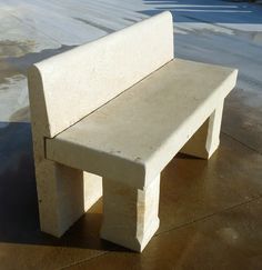 a concrete bench sitting on top of a cement slab in the middle of a parking lot