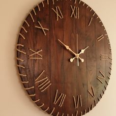 a large wooden clock with roman numerals on the face and numbers painted on it