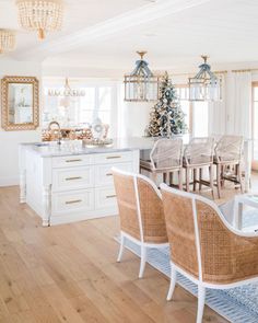 a dining room table and chairs in front of a christmas tree