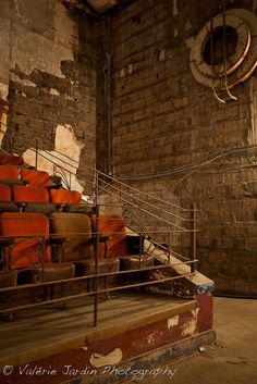 an old brick building with lots of orange chairs