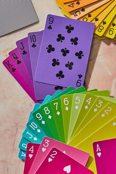 playing cards with numbers and symbols on them sitting on a marble table next to some dices