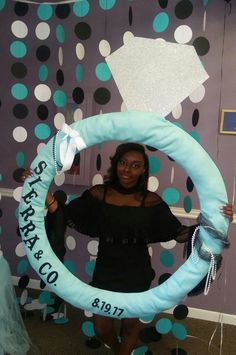 a woman standing in front of a backdrop holding a large blue ring with the words stargaps on it